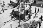 Na snímku ze 13. srpna 1961 můžete vidět obyvatele západní části Berlína, jak pozorují dělníky stavějící zeď.