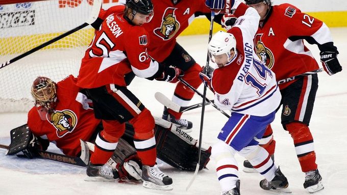 Tomáše Plekanec hrající za Montreal Canadiens bojuje o kotouč v souboji s hráči Ottawa Senators (zleva doprava brankář Mike Brodeur, dále Erik Karlsson, Chris Phillips a Mike Fisher).