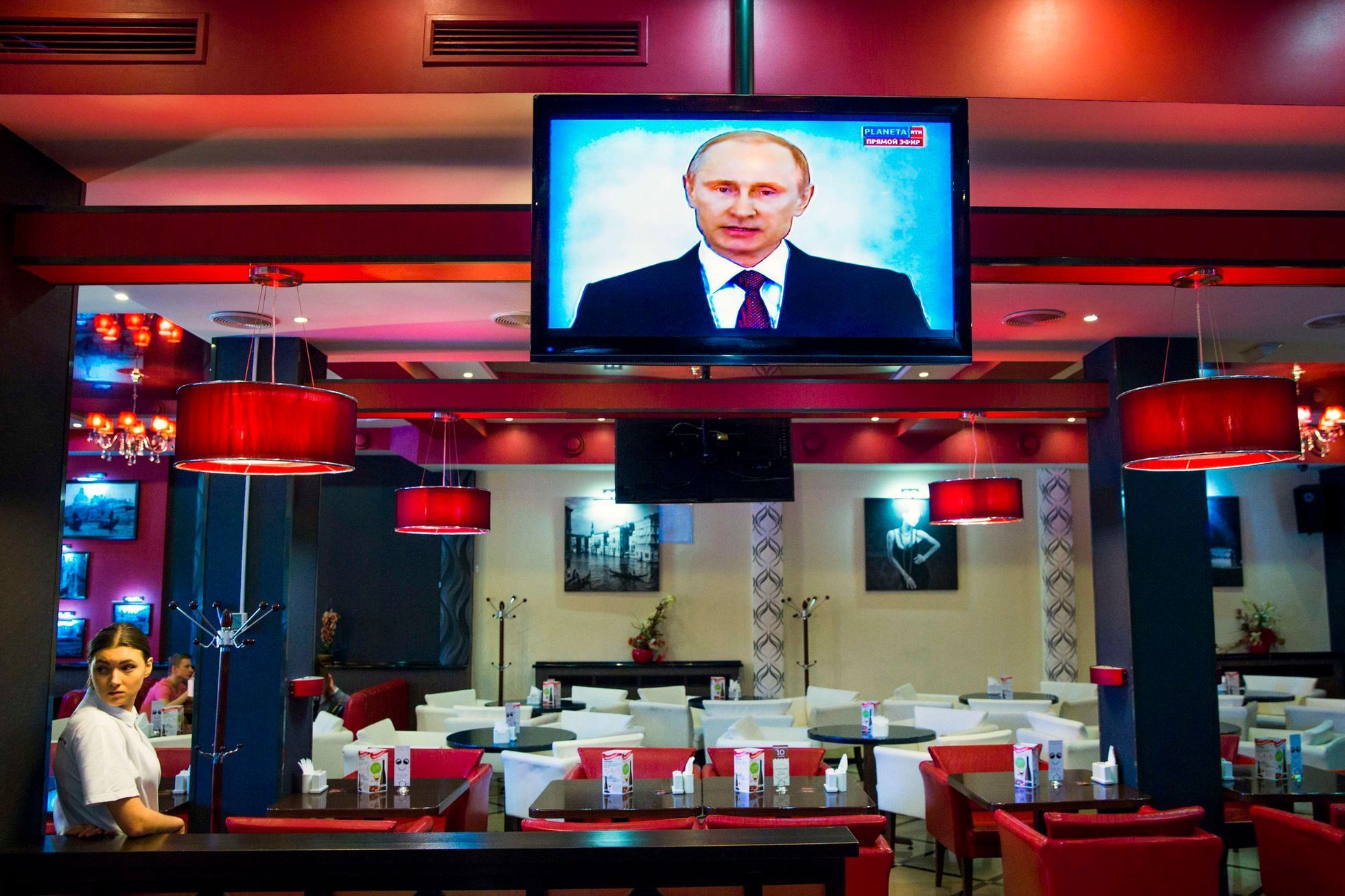 Obsluha pizzerie Simferopolu sleduje projev ruského prezidenta Vladimira Putina