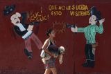 Žena prochází kolem obchodu se střelnými zbraněmi v San Pedro Sula (Honduras). Město je známé tím, že „počtem 159 vražd na 100 000 obyvatel předstihlo dokonce mexické Ciudad Juárez, považované za nejnebezpečnější místo na světě“.
(Honduras, 11. března 2012 - Esteban Félix)