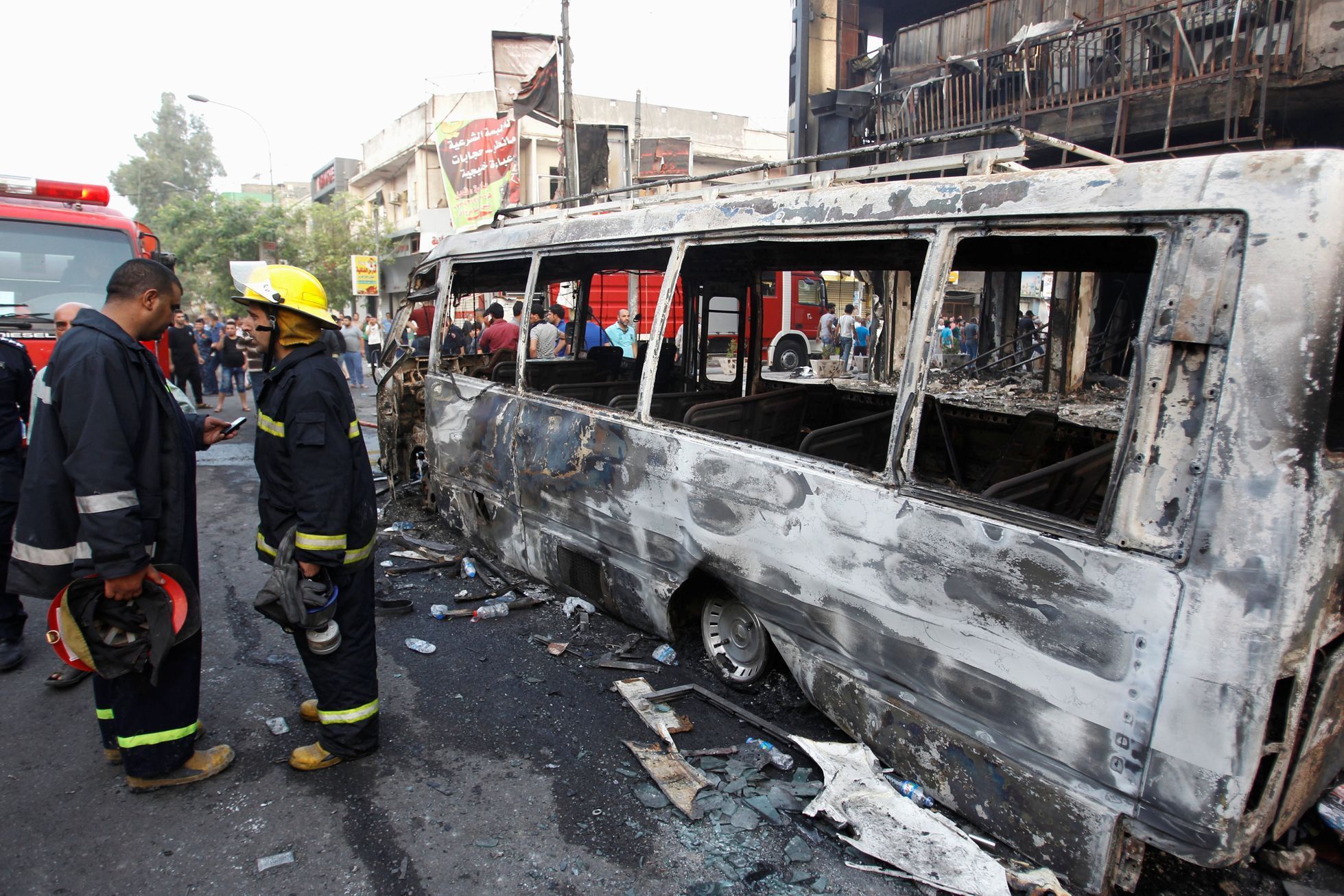 Firemen inspect the site of a suicide car bomb in the Karrada shopping area, in Baghdad