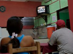 Kubánci v havanské restauraci sledují projev Raúla Castra o "normalizaci vztahů" se Spojenými státy.