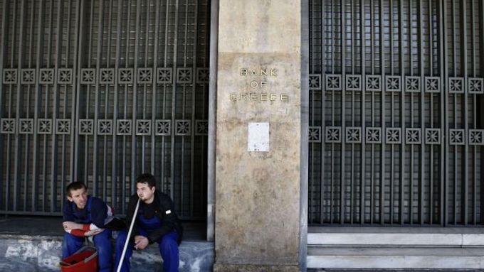 Pracovníci úklidové čety odpočívají před budovou řecké centrální banky.