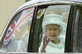 Královna Alžběta II. za okénkem luxusního automobilu během cesty do katedrály Sv. Pavla.