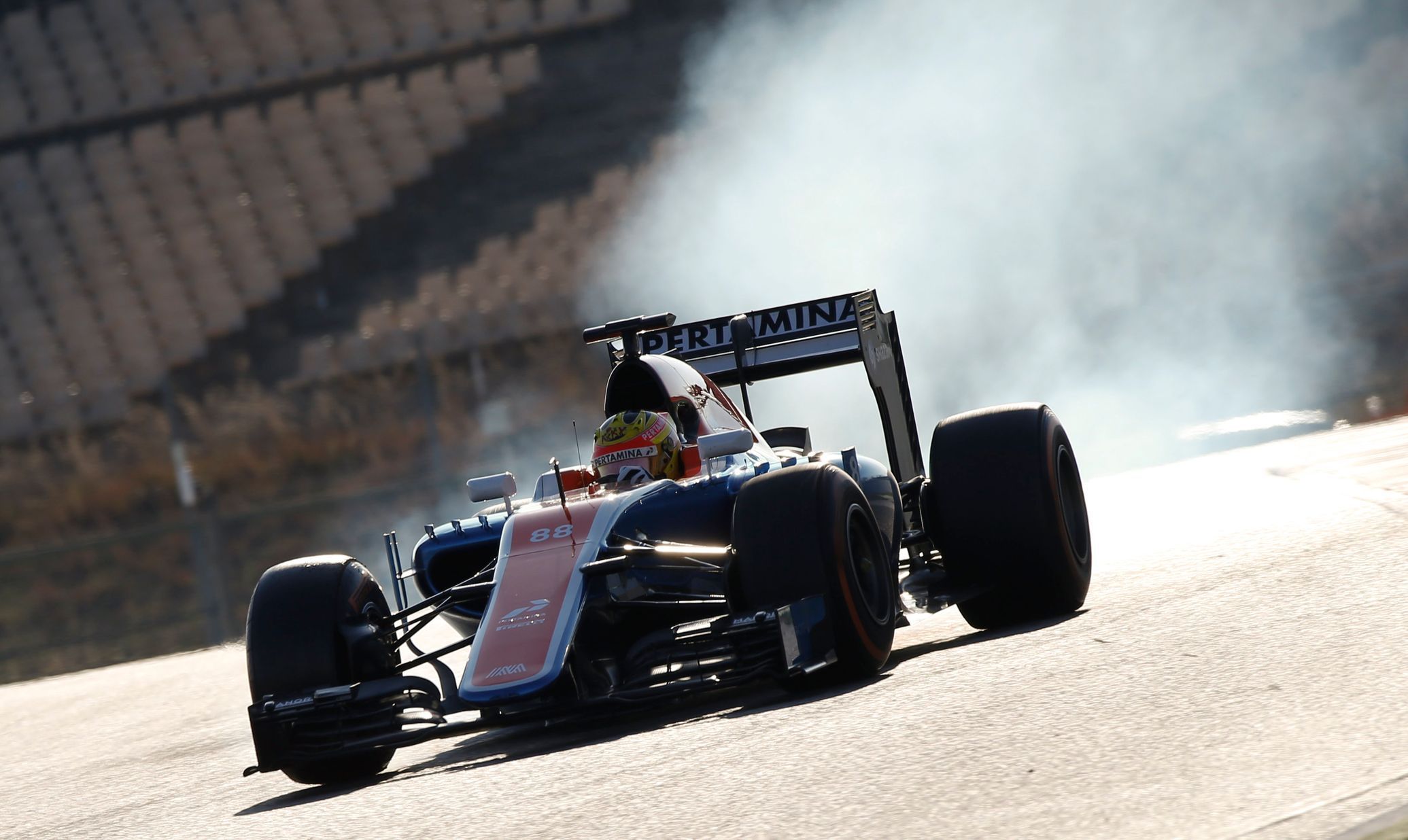 Tyres smoke as Manor Racing Formula One driver Haryanto of Indonesia takes a curve with his car during the third testing session ahead of the upcoming season at the Circuit Barcelona-Catalunya in Mont