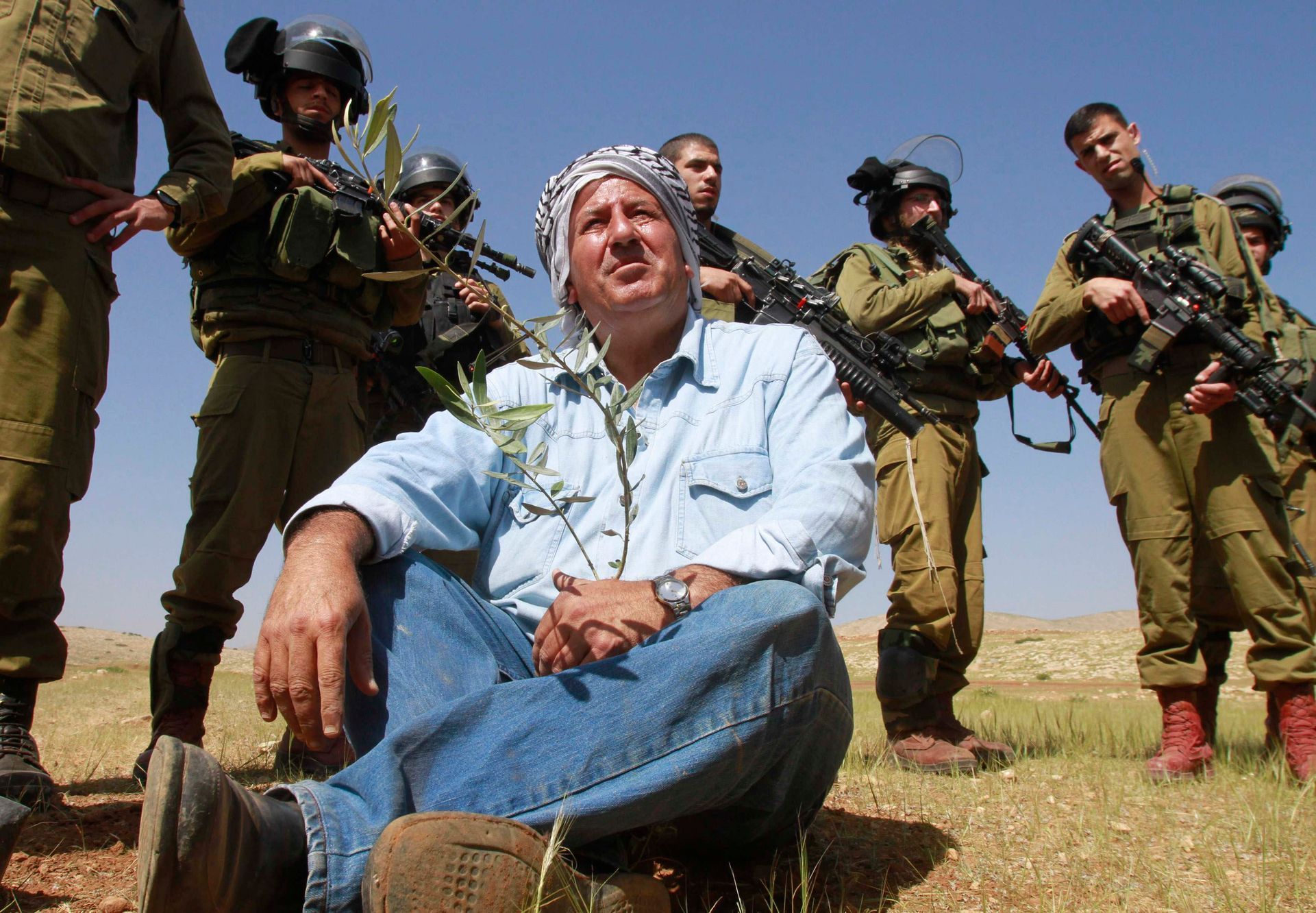 Izraelští vojáci a palestinský farmář v údolí Jordánu