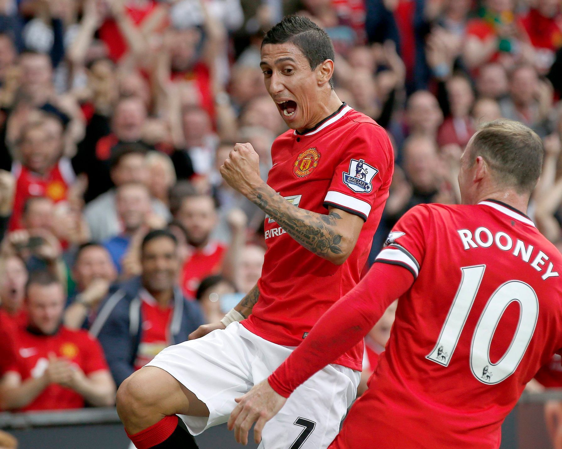 Manchester United's Di Maria celebrates with teammate Rooney after scoring a goal against Queens Park Rangers during their English Premier League soccer match at Old Trafford in Manchester