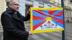 Mikuláš Bek vyvěšuje tibetskou vlajku.