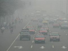 Smog zahaluje jednu z pekingských dopravních tepen.