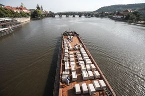 Foto: Mariánský sloup se vrací po sto letech do Prahy. Díly připluly ke Karlovu mostu