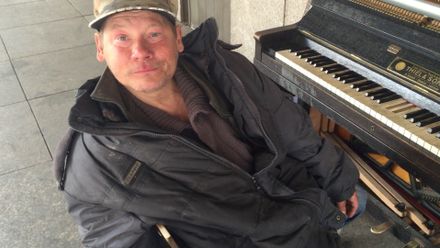 Bezdomovec zahrál fotografovi Šibíkovi před Národním divadlem Vltavu