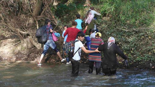 Uprchlíci překračují řeku Sutla na slovinské hranici.
