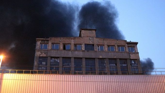 Hustý dým stoupající z hořícího bývalého průmyslového areálu v pražských Vysočanech.