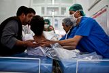 Zdravotnický personál přemisťuje pacienta na jiné lůžko. Mladého Afghánce zasáhla kulka a nutně potřebuje operaci.