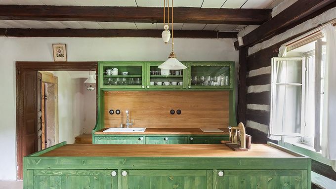 Kuchyně roubenky z 19. století nabízí moderní vaření. Spotřebiče jsou ukryty v dřevěné kredenci