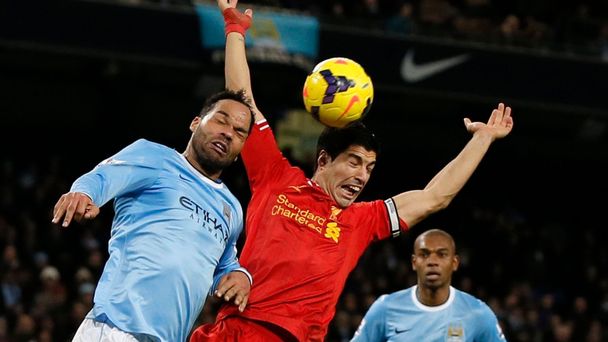 Liverpool's Suarez is challenged by Manchester City's Lescott during their English Premier League soccer match in Manchester