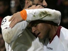 Marco Casseti z AS Řím (vlevo) gratuluje spoluhráči Mancinimu ke vstřelenému gólu do sítě Lyonu v osmifinále Ligy mistrů.
