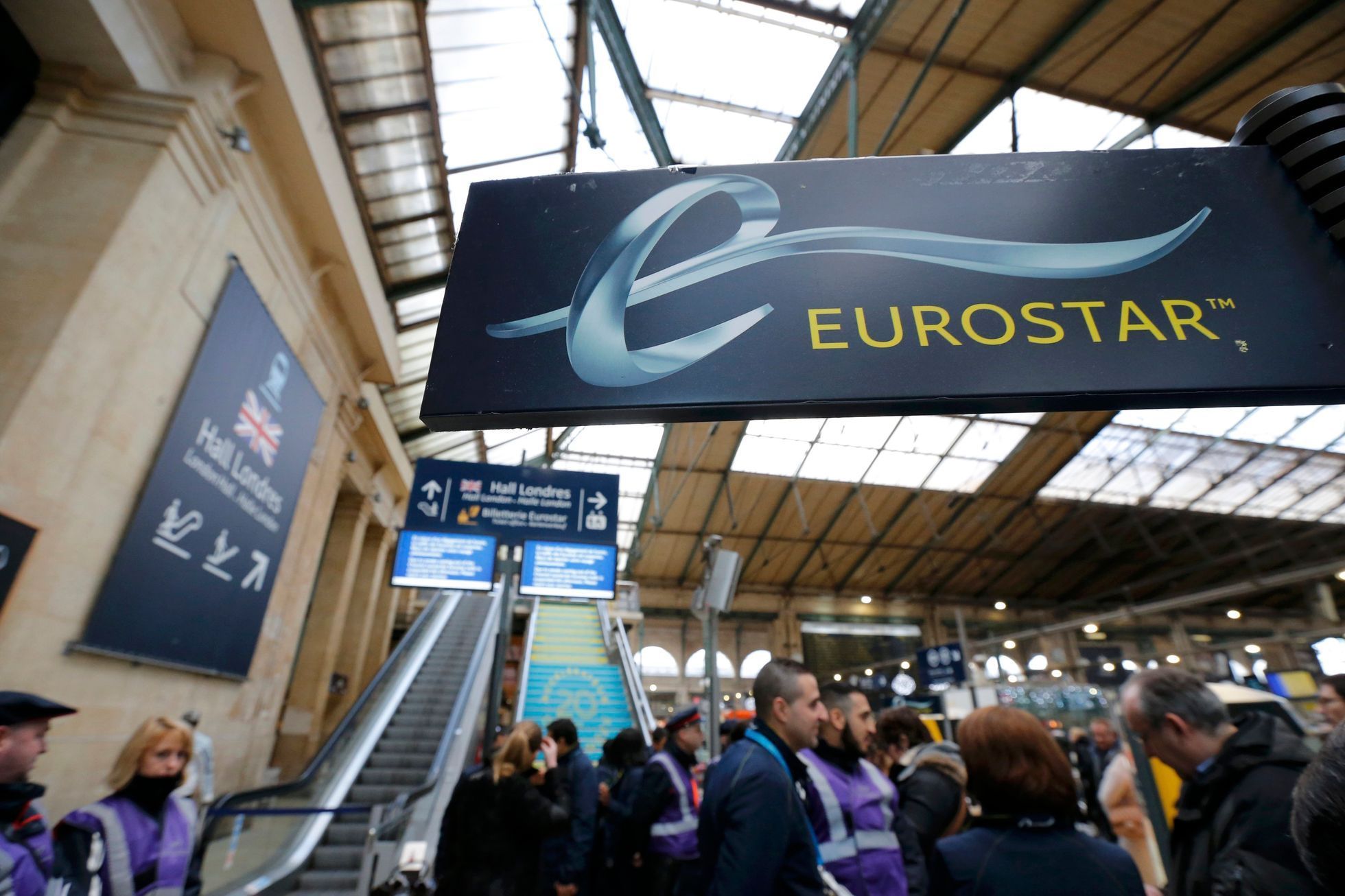 Passengers gather near the departure escalators at the Gare du Nord train station after the suspension of Eurostar rail traffic due to smoke coming out of the Channel tunnel