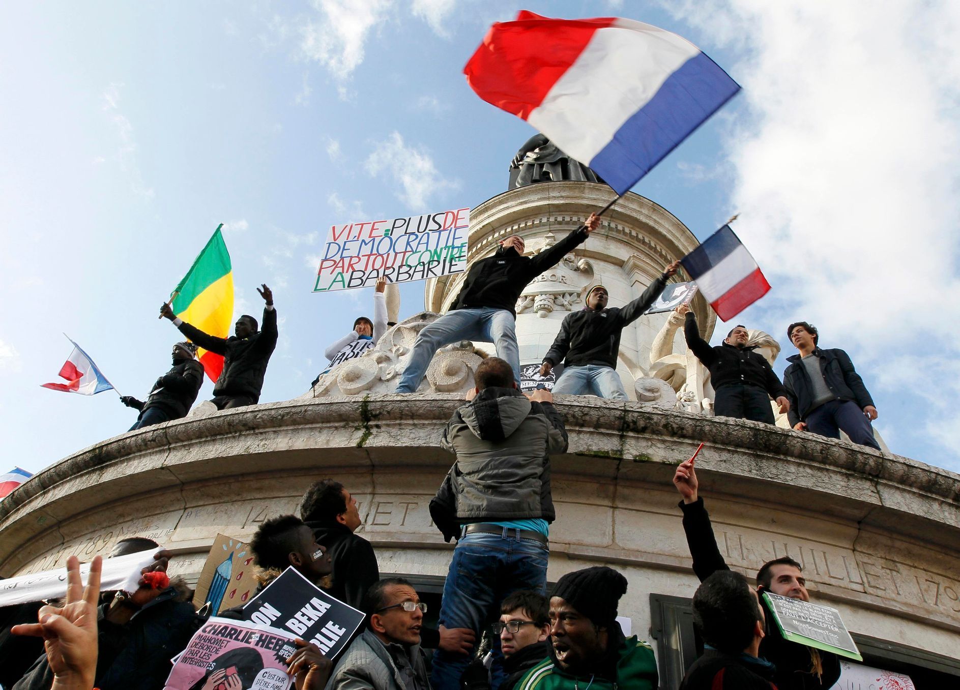 People holding a poster reading &quot;Quick more democracy everywhere against barbarism&quot; take part in a solidarity march (Marche Republicaine) in the streets of Paris