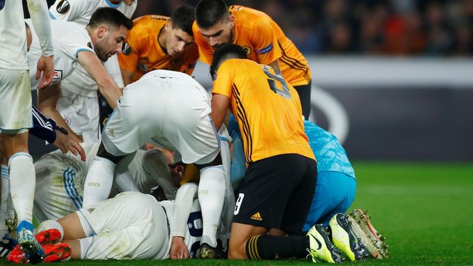Fotbalisté obou týmů se pokoušejí poskytnout první pomoc zraněnému zadákovi Slovanu Kenanu Bajričovi