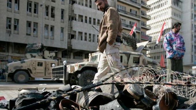 Majitelé těchto bot jsou mrtví. Iráčan stojí na tržišti Ghazil po sebevražedném atentátu.