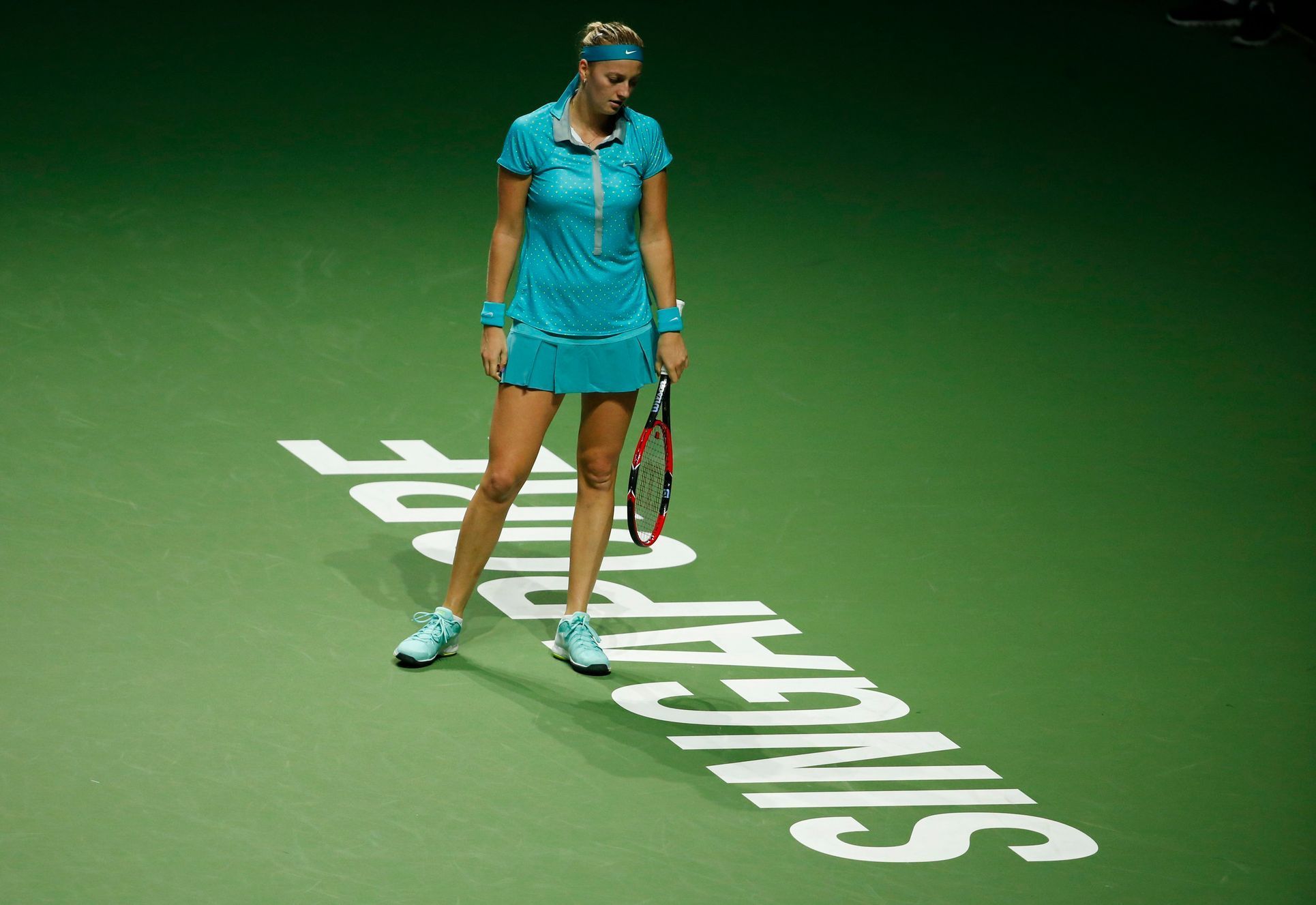 Kvitova of the Czech Republic reacts after losing a point against Radwanska of Poland during their WTA Finals singles tennis match at the Singapore Indoor Stadium