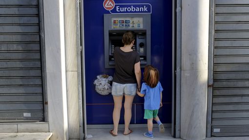 Matka s dcerou vybírají hotovost v jednom z aténských bankomatů. Řekové už z účtů kvůli obavám z bankrotu vybrali miliardy eur.
