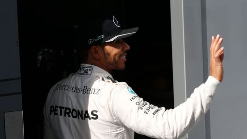 Mercedes F1 driver Lewis Hamilton waves to supporters in the paddock.