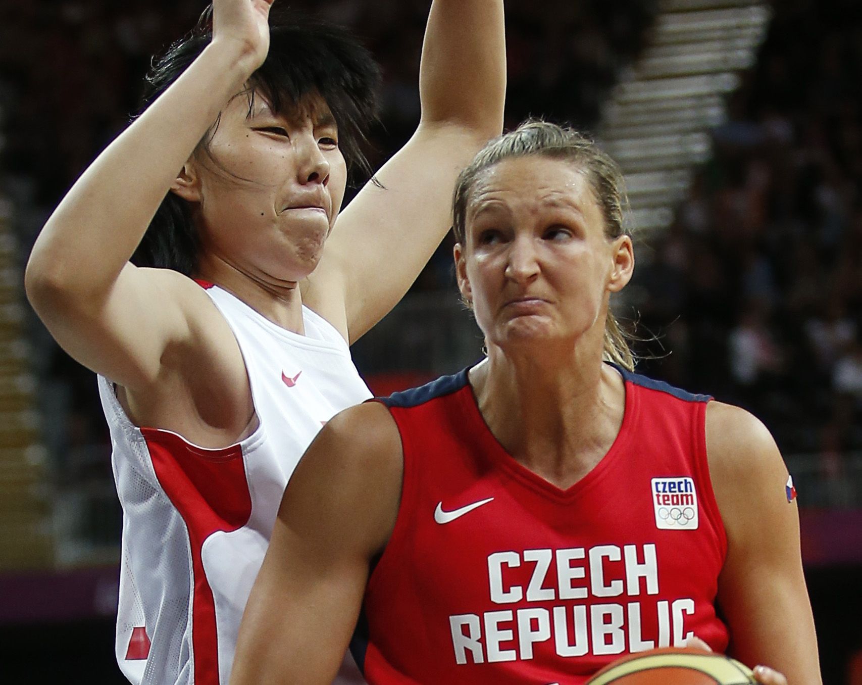 Česká basketbalistka Petra Kulichová se snaží prorazit obranu Číňanky Čen Nan v turnaji OH 2012 v Londýně.