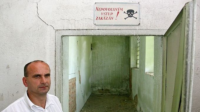 Václav Rychtařík v zamořené stodole. Na podlaze, stěnách a okolní půdě jsou viditelné známky skladování chemikálií.