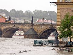 Karlův most je kvůli povodním uzavřen. Bagr odklízí naplavené kusy.