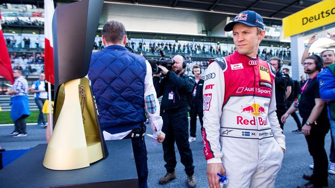 Mattias Ekström zálibně pohlíží na ultra moderní trofej pro šampiona DTM. Nakonec ji nad hlavu zvedl jeho kolega od Audi René Rast.