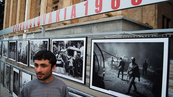 Muž stojí u panelu s fotografiemi zachycujícími napadení Československa v roce 1968. Fotografie byly umístěny před hlavní vchod gruzínského parlamentu.
