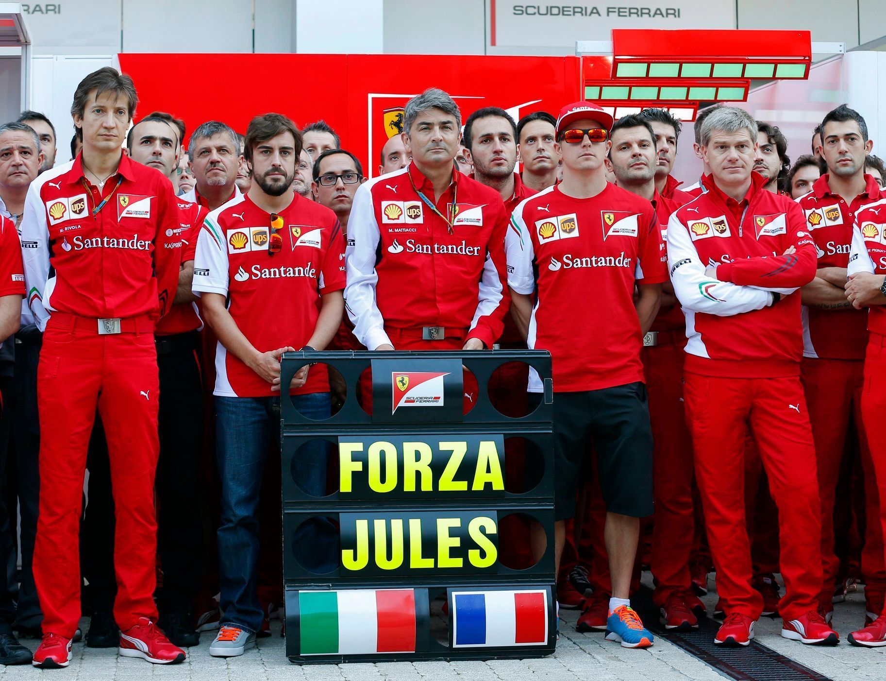 Members of Ferrari Formula One team pose with a sign in support of Marussia Formula One driver Bianchi of France before the first Russian Grand Prix in Sochi