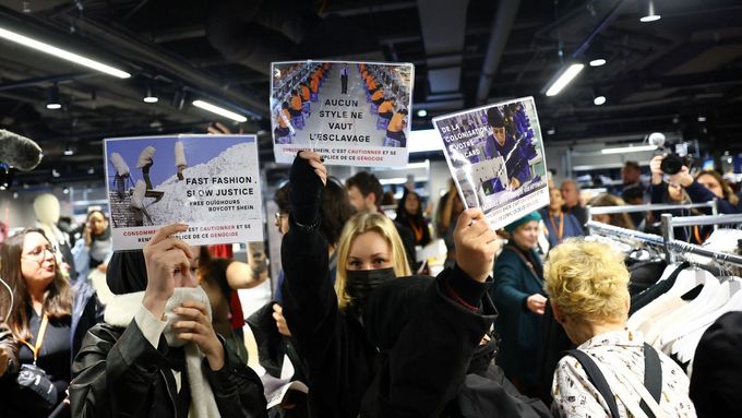 Demonstranti drží transparenty s nápisy „Rychlá móda, pomalá spravedlnost. Svobodu Ujgurům, bojkotujte Shein.“ během otevření obchodu Shein v pařížském obchodním domě.