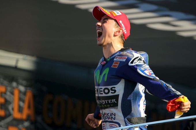 Jorge Lorenzo slaví vítězství v kvalifikaci třídy MotoGP ve Valencii.
