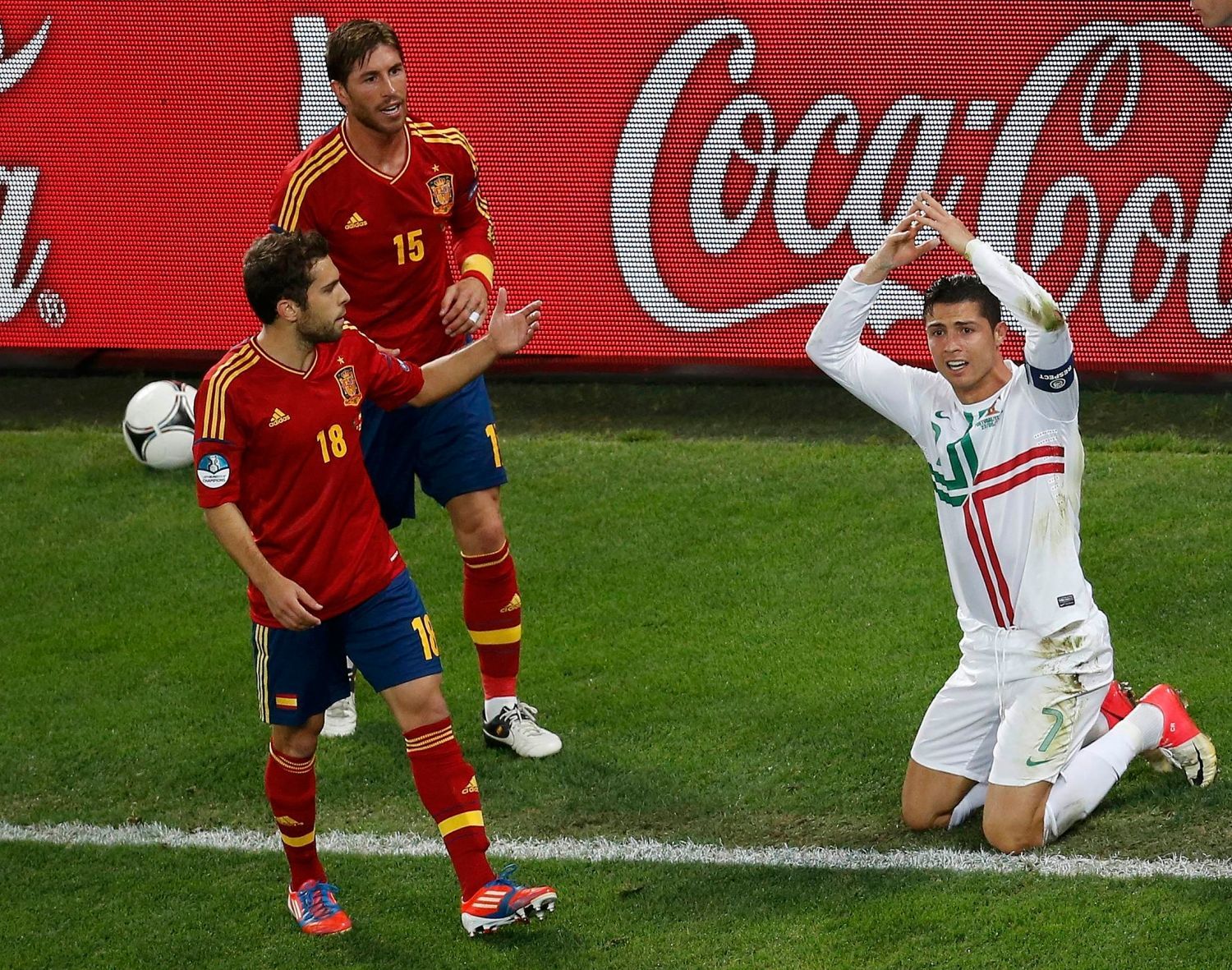 Cristiano Ronaldo gestikuluje a sledují ho při tom Jordi Alba (vlevo) a Sergio Ramos během semifinálového utkání mezi Portugalskem a Španělskem na Euru 2012.