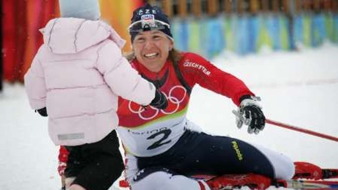 Kateřina Neumannová má zlato. Jako první gratulantka k ní běží dcera Lucie. Turín 2006.