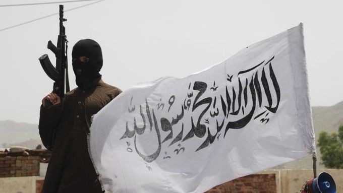Bojovník Talibanu s vlajkou na pákistánském území.