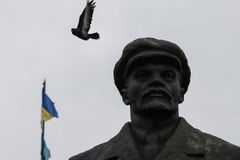 Holub letící nad vztyčenou ukrajinskou vlajkou před kanceláří starosty ve Slavjansku.