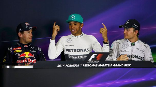 Hamilton, seated between Vettel and Rosberg, gestures as he speaks during a news conference after the qualifying session for the Malaysian F1 Grand Prix at Sepang International Circuit outside Kuala L