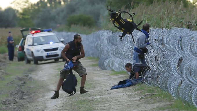 Uprchlíci přelézají plot v Maďarsku