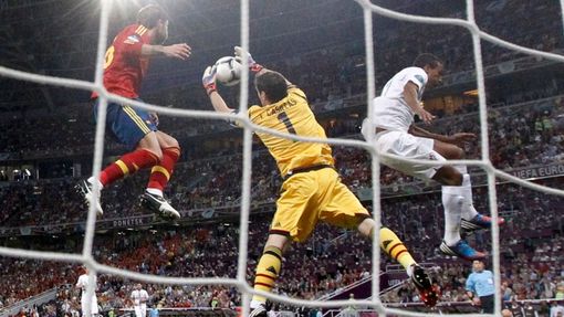 Iker Casillas chytá střelu Andrése Iniesty a asistuje mu Nani během semifinále na Euru 2012.