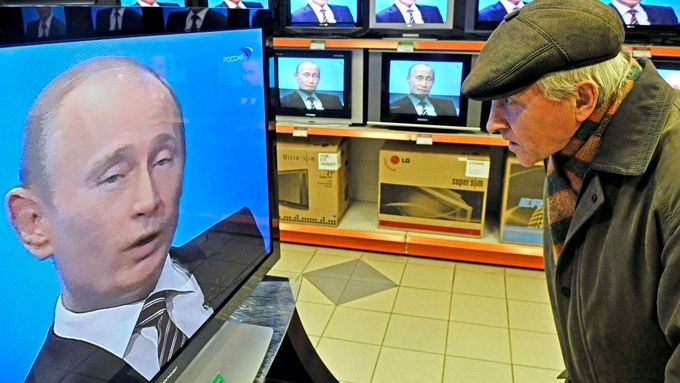 Ruský stařík poslouchá projev premiéra Putina v jedné z moskevských prodejen s elektronikou