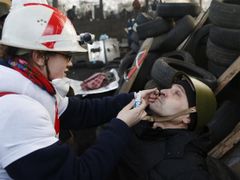A medic cleans the eyes of an anti-government protester as he mans a barricade in Kiev February 21, 2014.