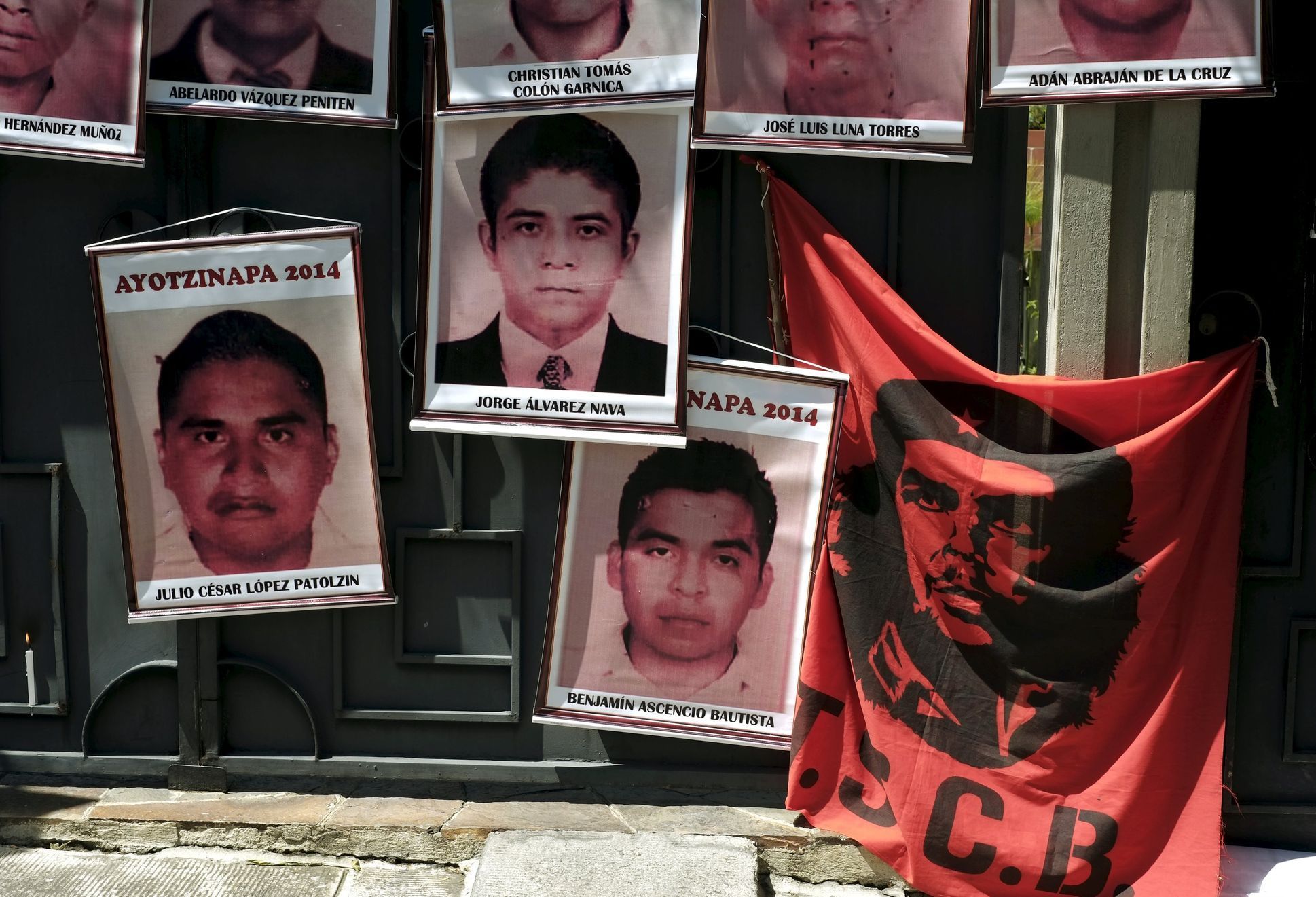Pictures of the 43 Mexican students who disappeared a year ago are seen hung up near a banner of a revolutionary leader Che Guevara, on the entrance gate of the Mexican embassy in La Paz, Bolivia