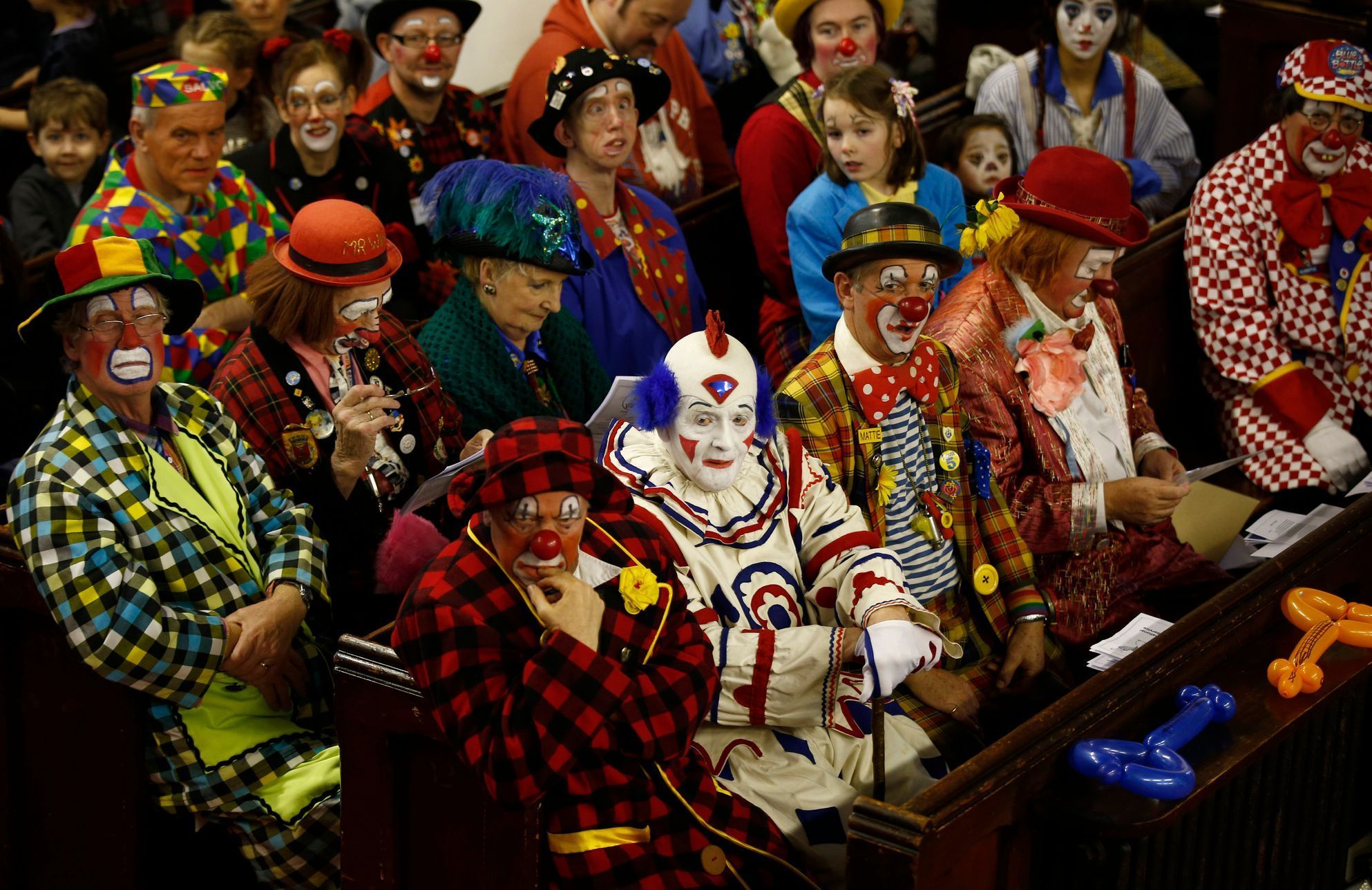 Clowns sit in the pews at the All Saints Church during the Grimaldi clown service in Dalston, north London