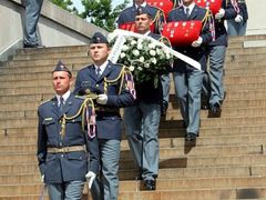 Vojáci vynášejí generálova vyznamenání ze smuteční síně po schodech Národního památníku na Vítkově.