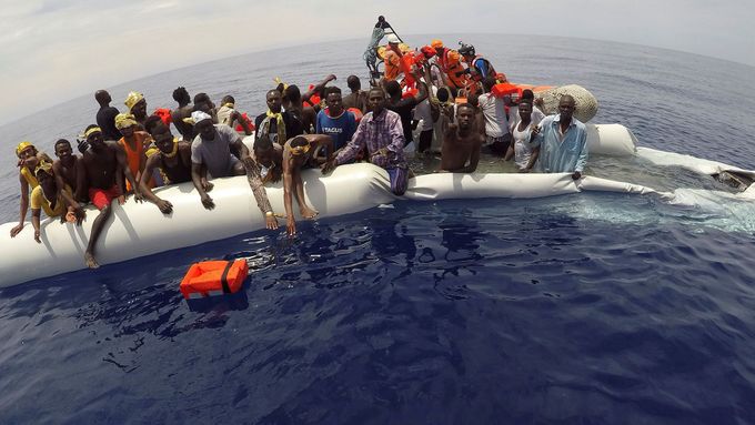 Afričtí migranti ve vlnách Středozemního moře.