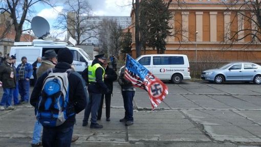Konvoj v Praze, demonstrant s hákovým křížem na vlajce.